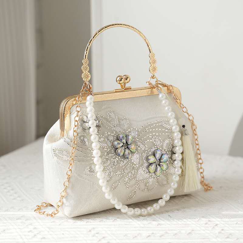 Handcrafted clutch embroidered with flowers decorated with zircons.