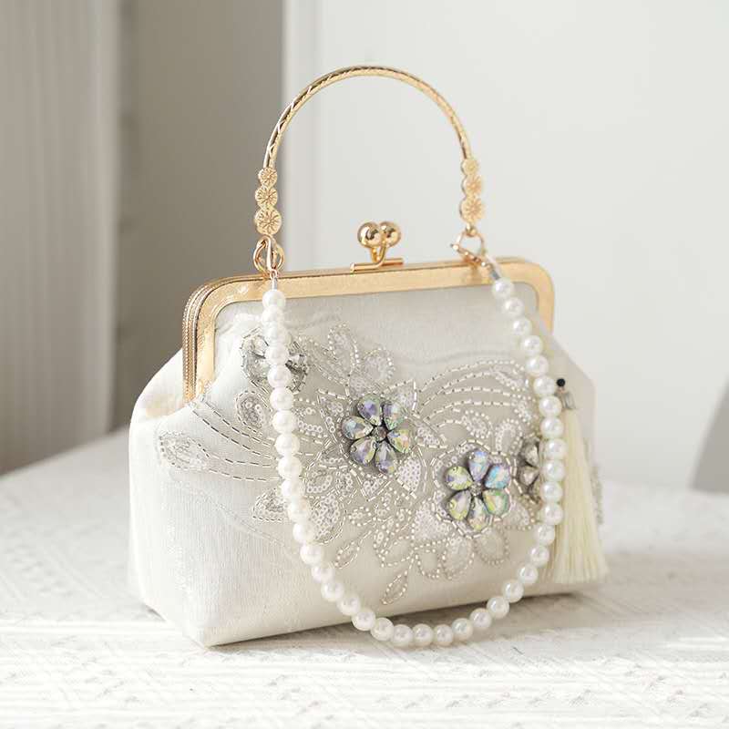 Handcrafted clutch embroidered with flowers decorated with zircons.