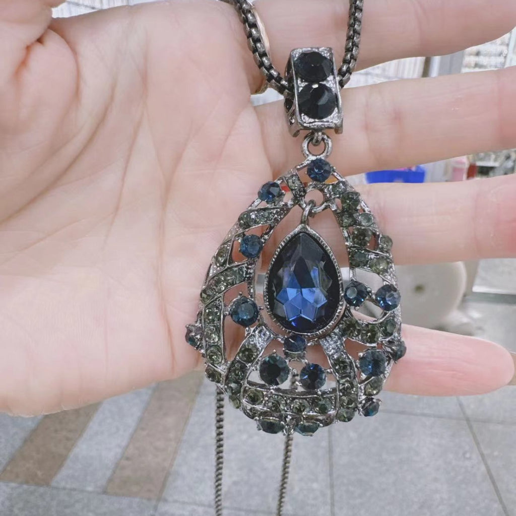 Collier long pour femme en métal, avec pendentif vintage ajouré en forme de goutte, saphir et cristal, et chaîne strass.
