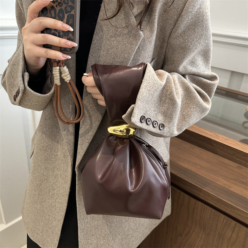 New women's retro pleated bag: a stylish, minimalist, and unique bucket bag featuring a spacious interior and an elegant aesthetic.