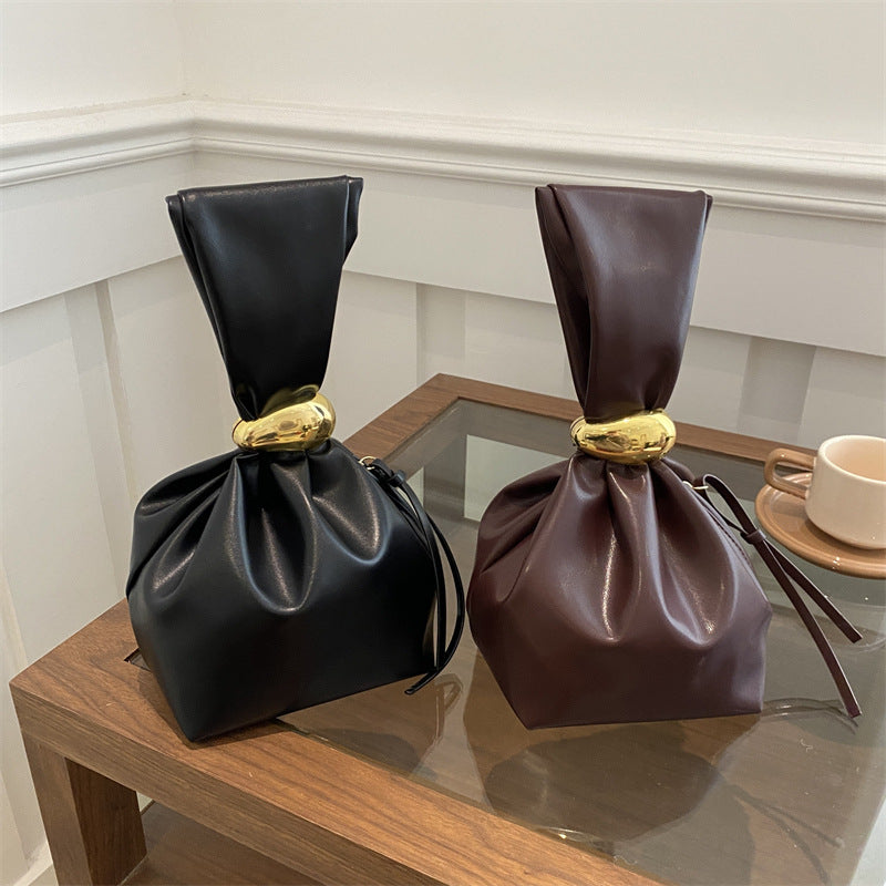 New women's retro pleated bag: a stylish, minimalist, and unique bucket bag featuring a spacious interior and an elegant aesthetic.